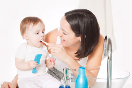 cleaning baby's teeth twice a day with soft tooth brush